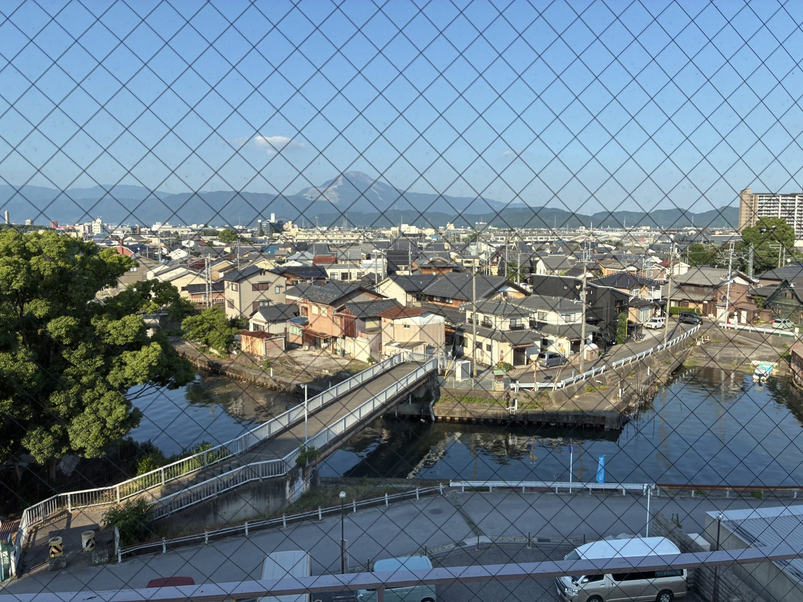 みなと館の部屋の窓から金網越しに見えた長浜の町並みと山