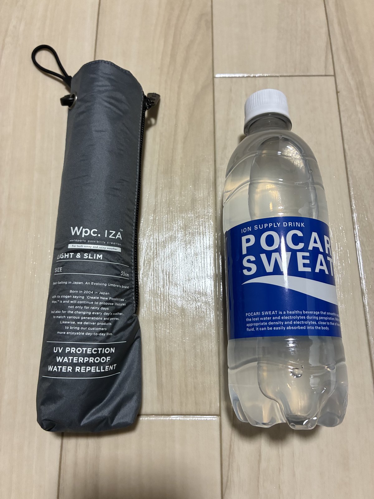 たたんだWpc. IZAの日傘とペットボトルの大きさ比べ