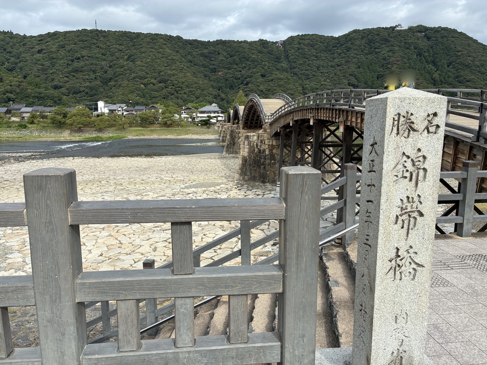 「名勝 錦帯橋」の石柱と橋、山の上に岩国城
