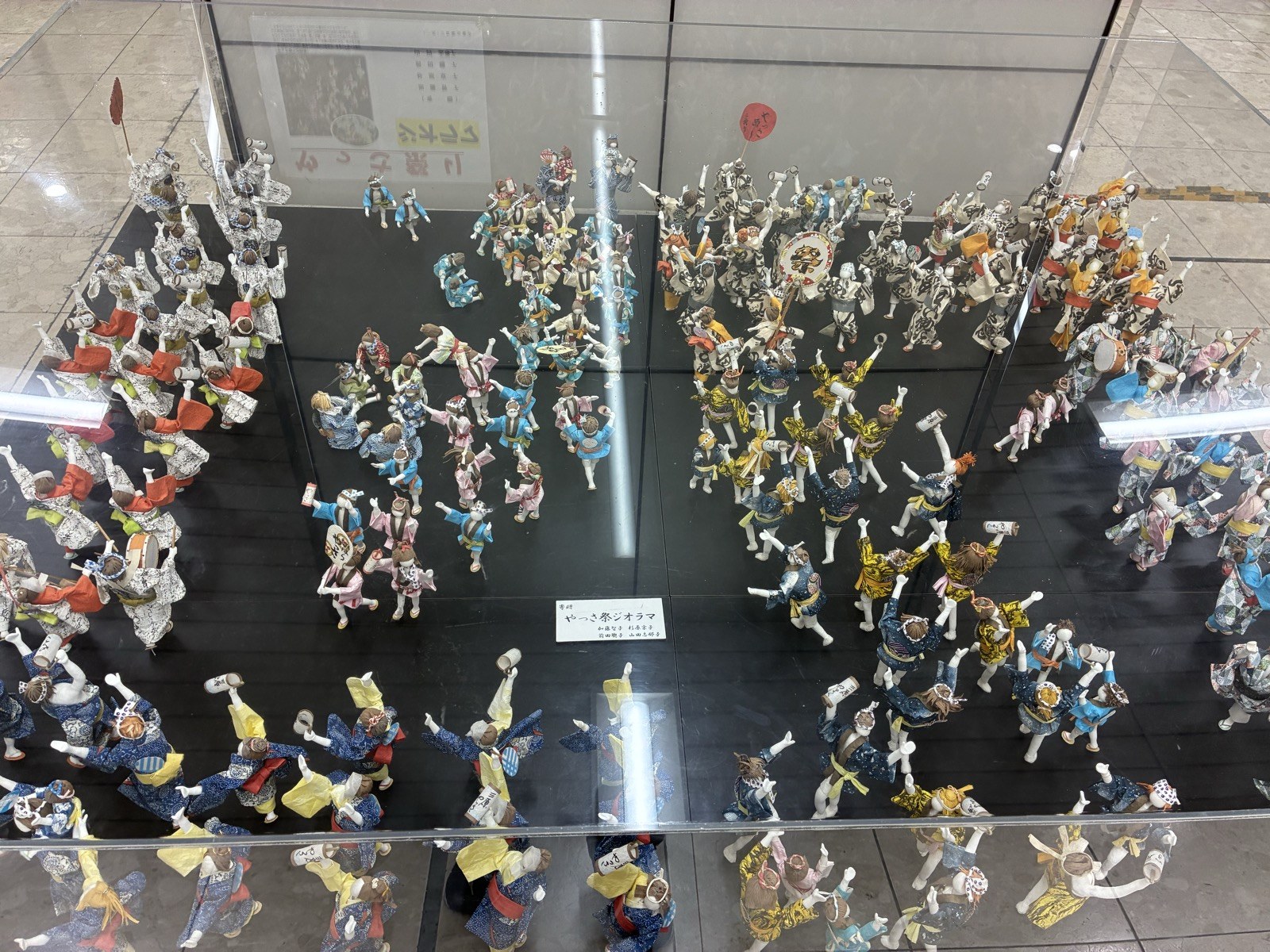 三原駅の中のやっさ祭ジオラマ。踊り手の人形がケースいっぱいに並んでいます