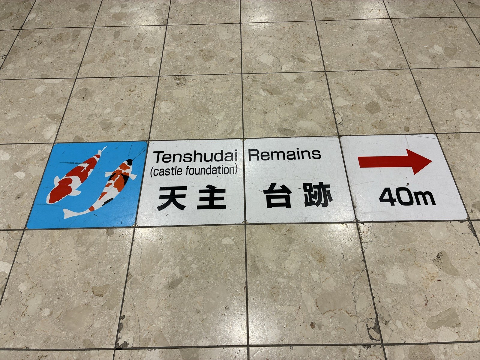 駅の床の案内。天主台跡まで40メートルとあります