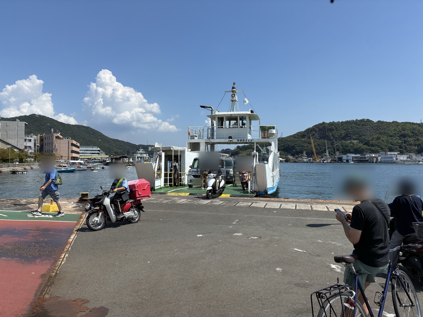 渡船から降りてくる郵便配達のバイクと車