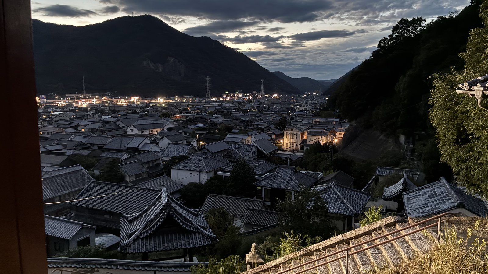普明閣から見下ろした日暮れの町。瓦屋根の向こうに灯りがともりはじめています