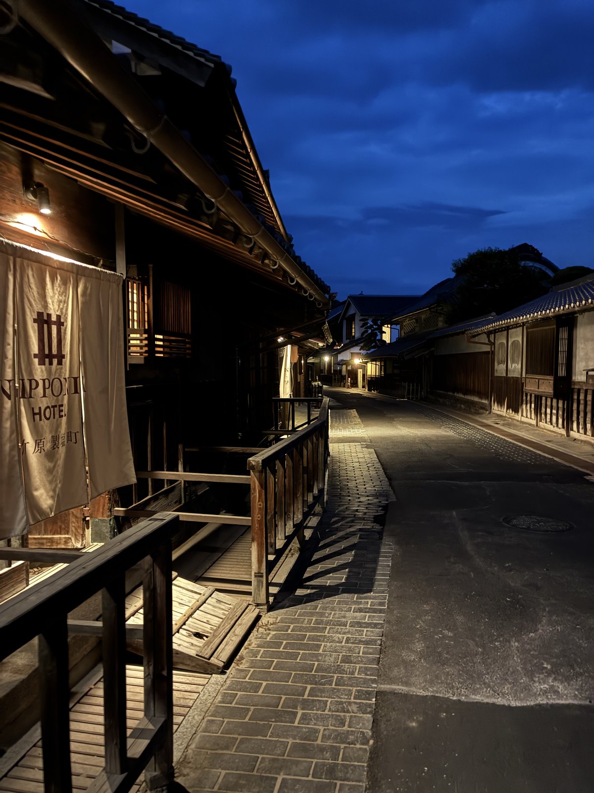 夜の通り。暖簾に灯りが当たっています