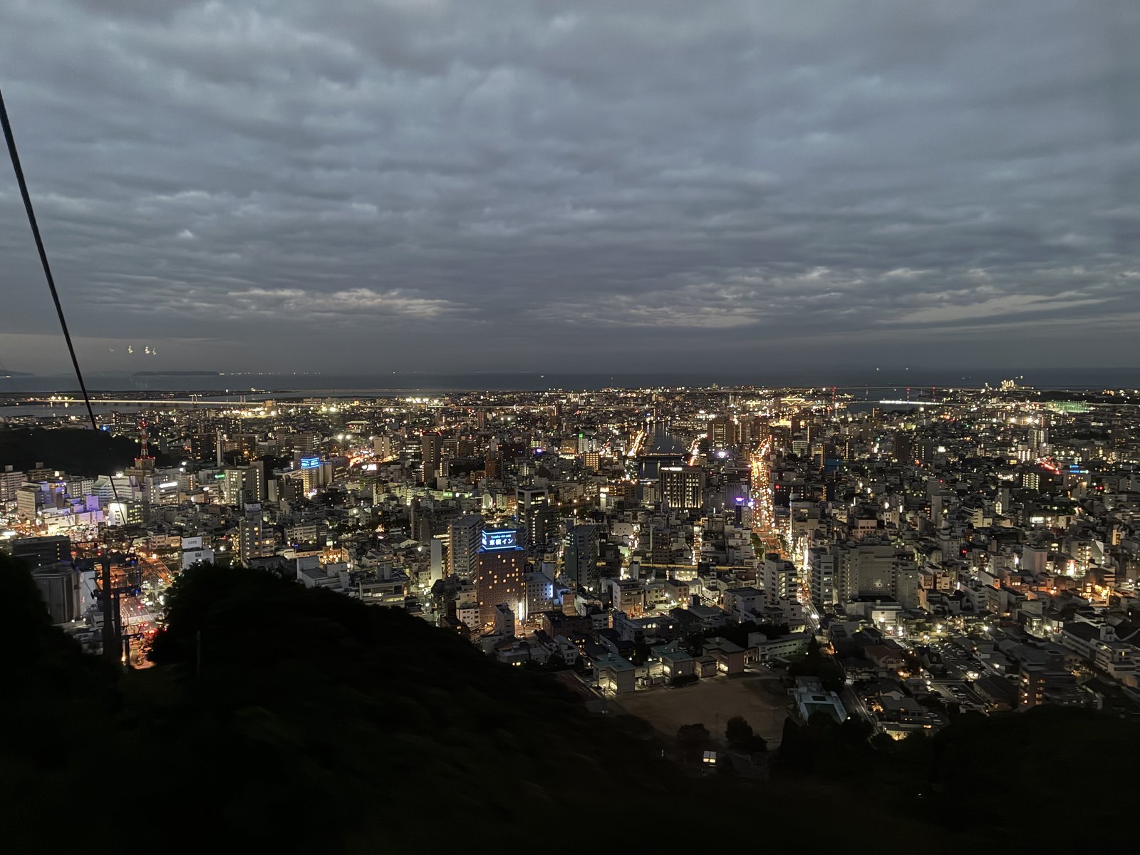 眉山ロープウェイの下りのゴンドラから見た、明かりのついた徳島の夜景とケーブル