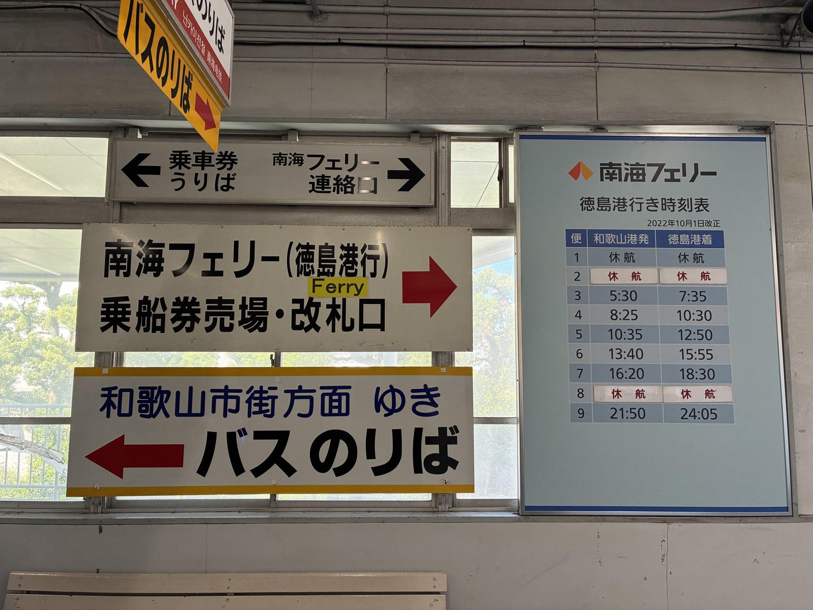 和歌山港駅の「南海フェリー連絡口」の案内と、徳島行きの時刻表