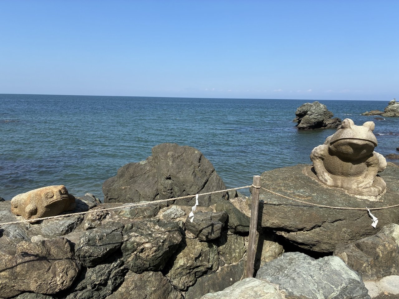 二見興玉神社の海沿いの岩の上に置かれたカエルの像