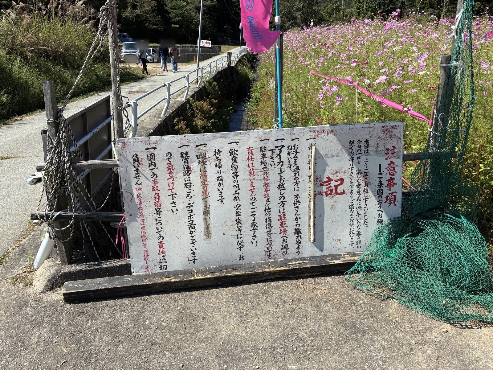 入口に立つ、足元の注意書きの看板
