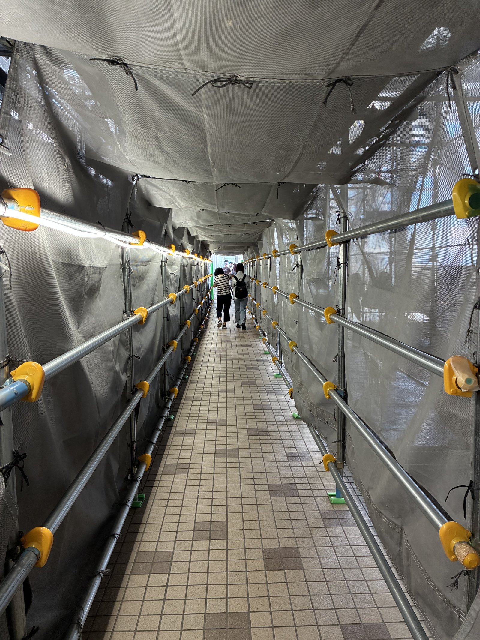 工事の足場とシートに囲まれた、渦の道の入口近くの通路